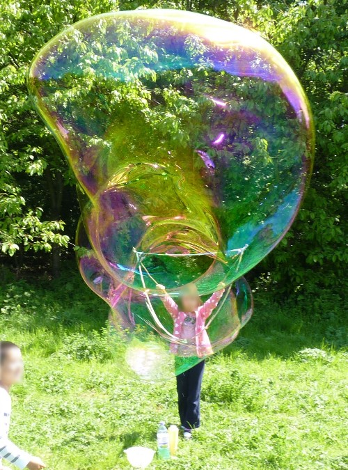 children making giant soap bubbles on a sunny day