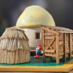 A mushroom-shaped granary with corn crib, haystack and Papa smurf figurines