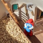Papa smurf inspecting wheat inside a miniature granary