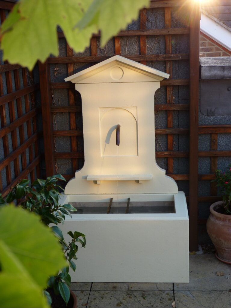 homemade fountain with basin, stele and pediment