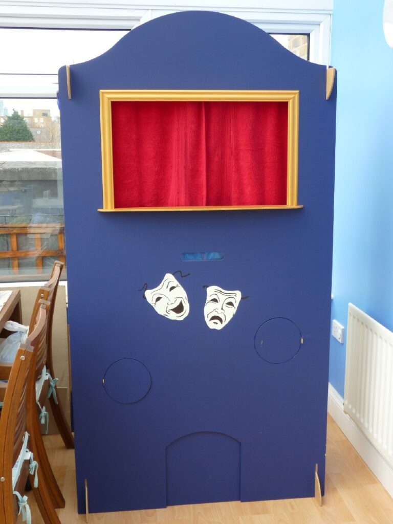 home-made puppet theatre with red curtain and comdy and tragedy masks